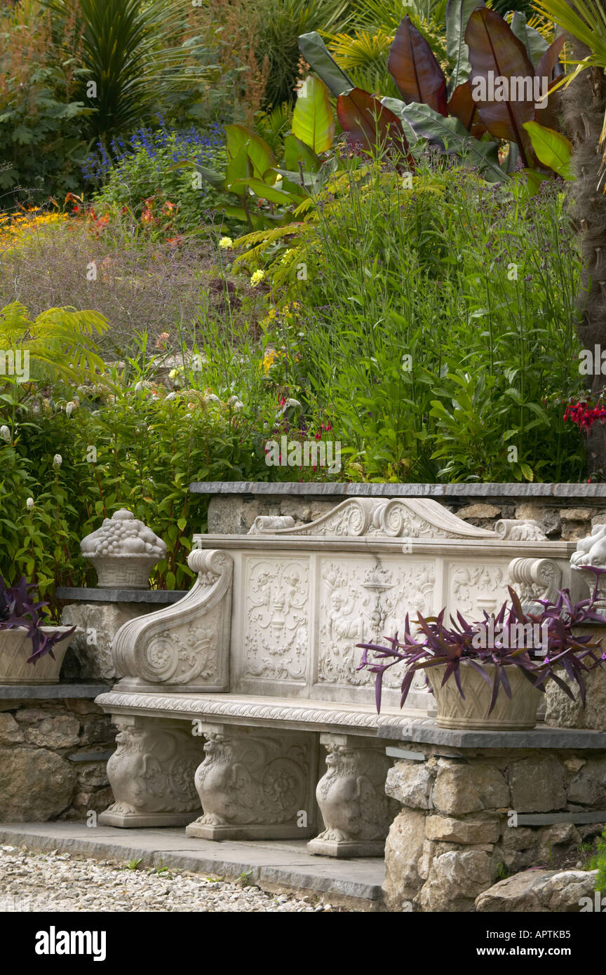 Yewbarrow chambre jardin avec banc calcaire plantation exotique avec des piliers de croissance aux côtés de l'hosta Fuschia Banque D'Images
