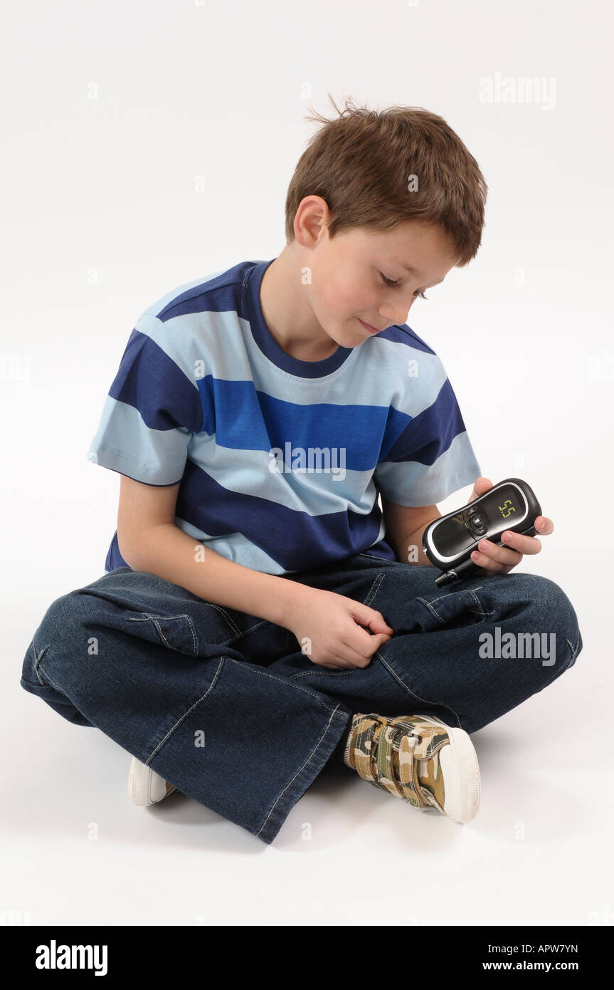 Les jeunes boy doing test niveau de glucose de sang. 2008 device Banque D'Images