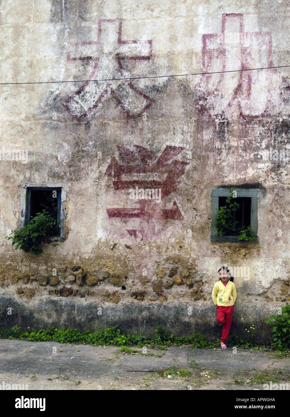 Révolution Culturelle vieux slogans peints sur les murs du village fortifié Hakka traditionnels dans Guangdong Chine Banque D'Images
