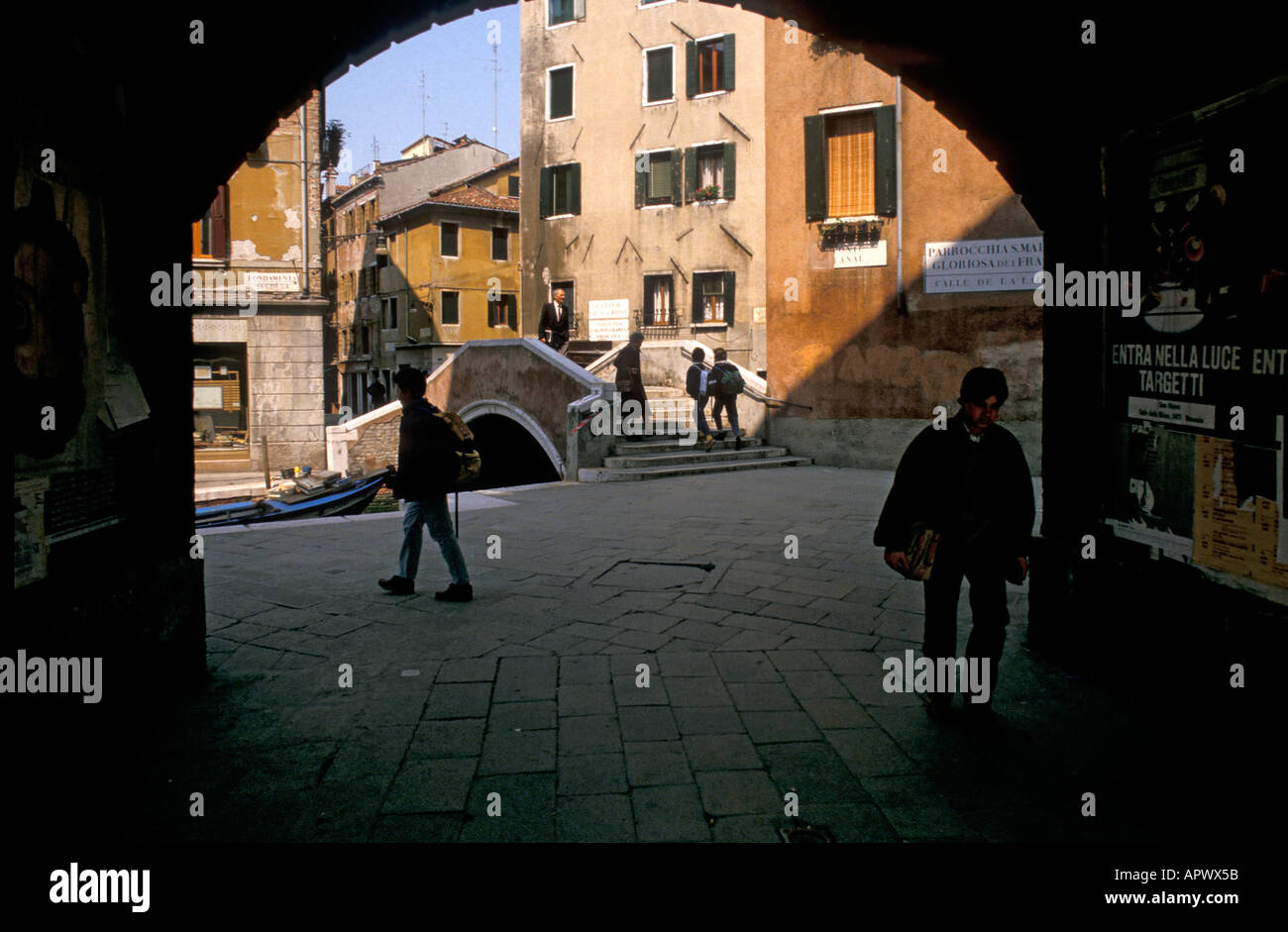 Europe Italie Venise retour de l'école les enfants de l'école sous une arche le long d'un canal de Venise Banque D'Images