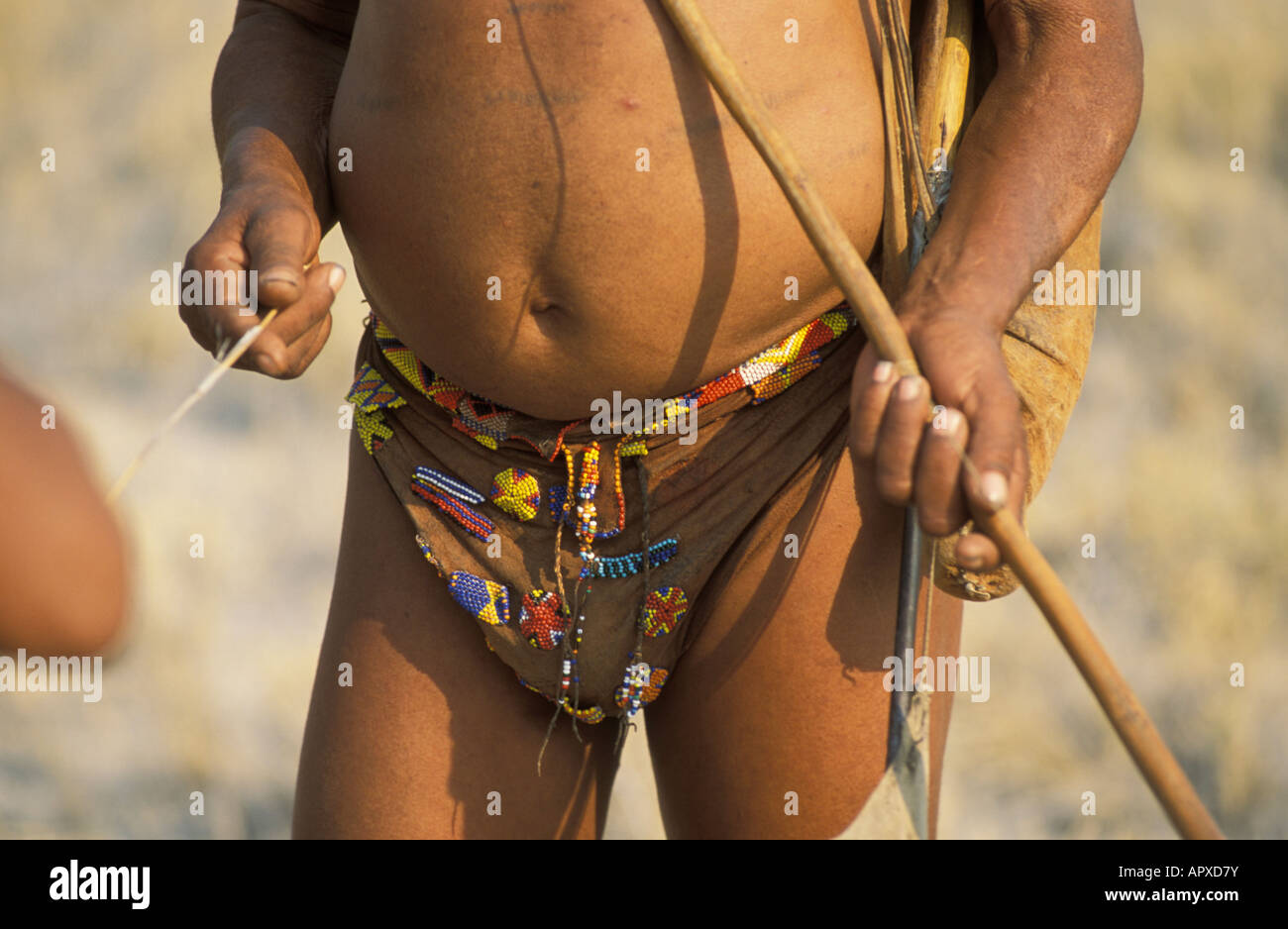 Un portrait d'un Bushman dans un pagne en perles avec son arc et flèches Banque D'Images