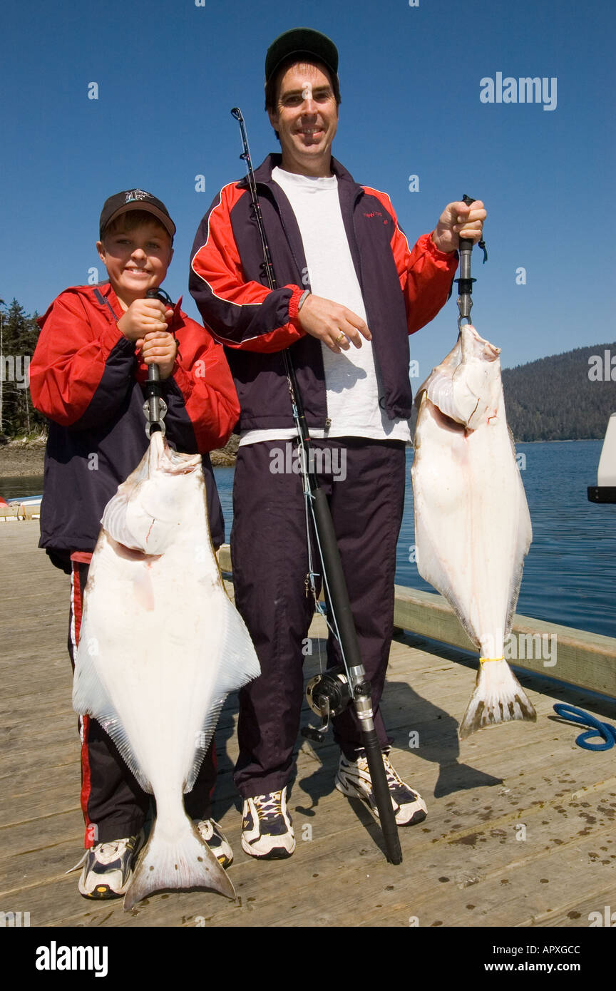 Pêche de l'ALASKA USA heureux fils Et papa holding up Halibut prises du jour Cook Inlet près de Homer MR Banque D'Images