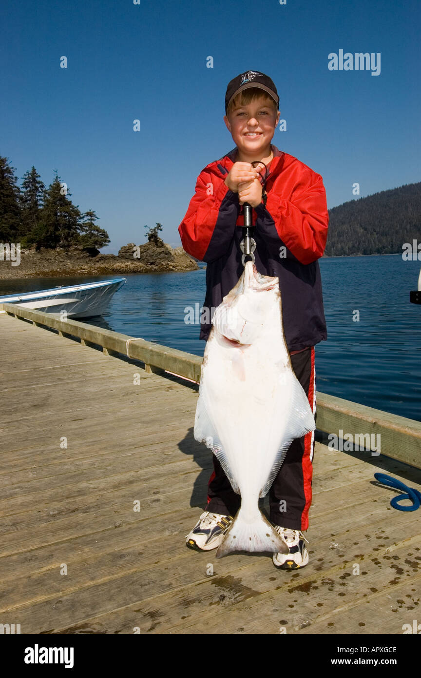 Pêche de l'ALASKA USA Happy boy holding up un grand flétan noir capturées dans Cook Inlet, près d'Homer MR Banque D'Images