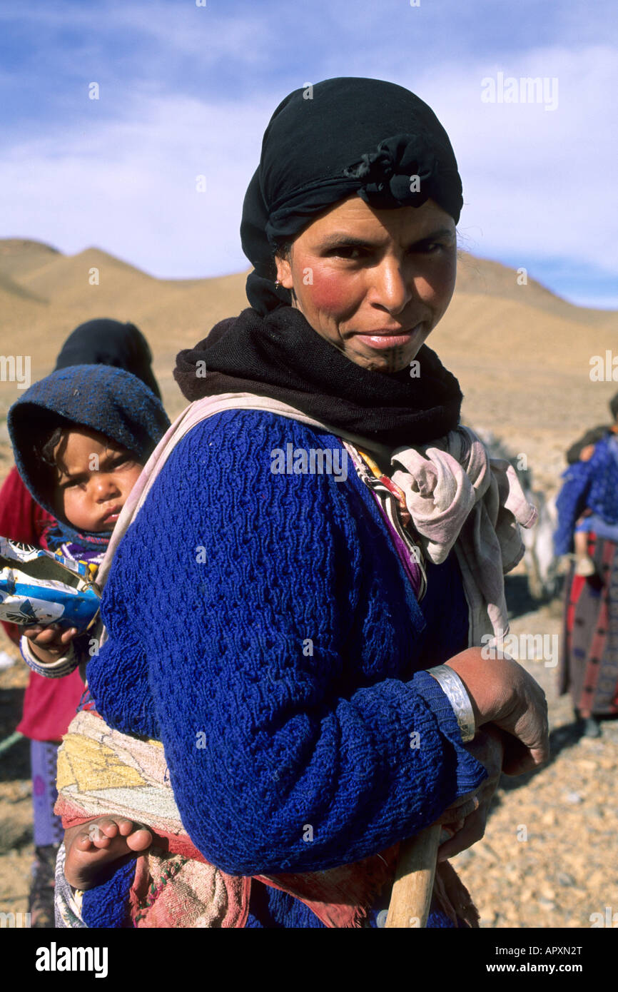 Femme berbère avec un enfant sur le dos dans les montagnes de l'Atlas Banque D'Images