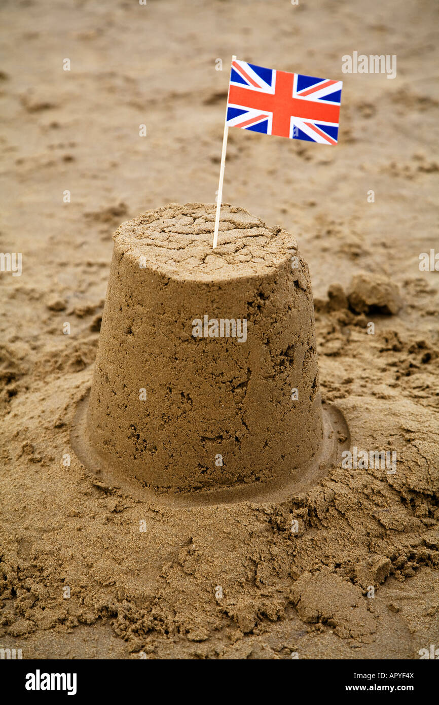 Château de sable sur la plage avec un drapeau britannique Banque D'Images