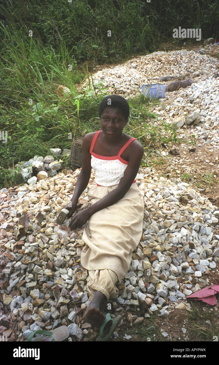 Un jeune noir femmes africaines travaillant comme briseur de pierre faire du gravier sur la route, près d'Ashanti Kumasi Ghana région Afrique de l'Ouest Banque D'Images