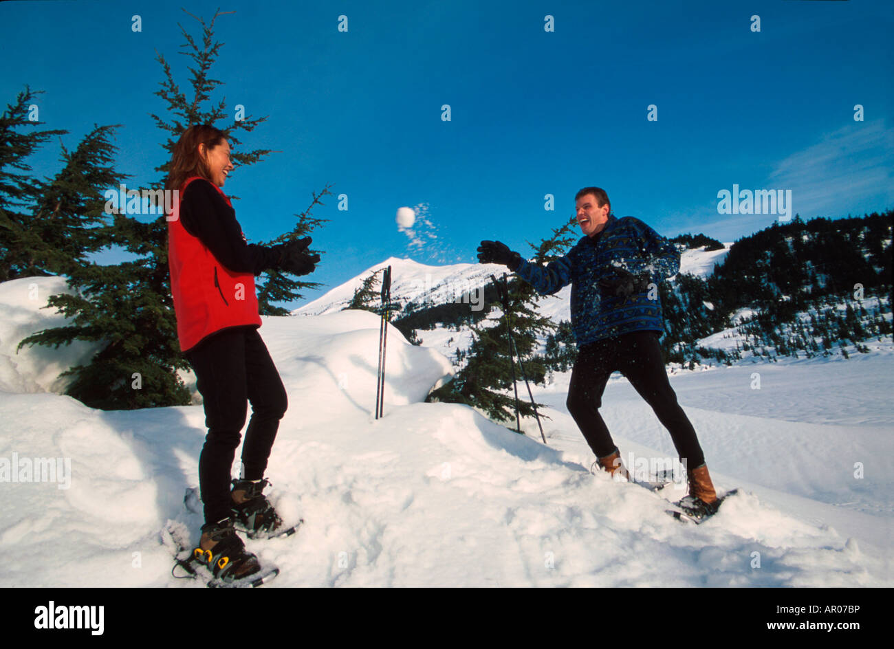 La raquette et couple Having Snowball Fight KP AK Banque D'Images