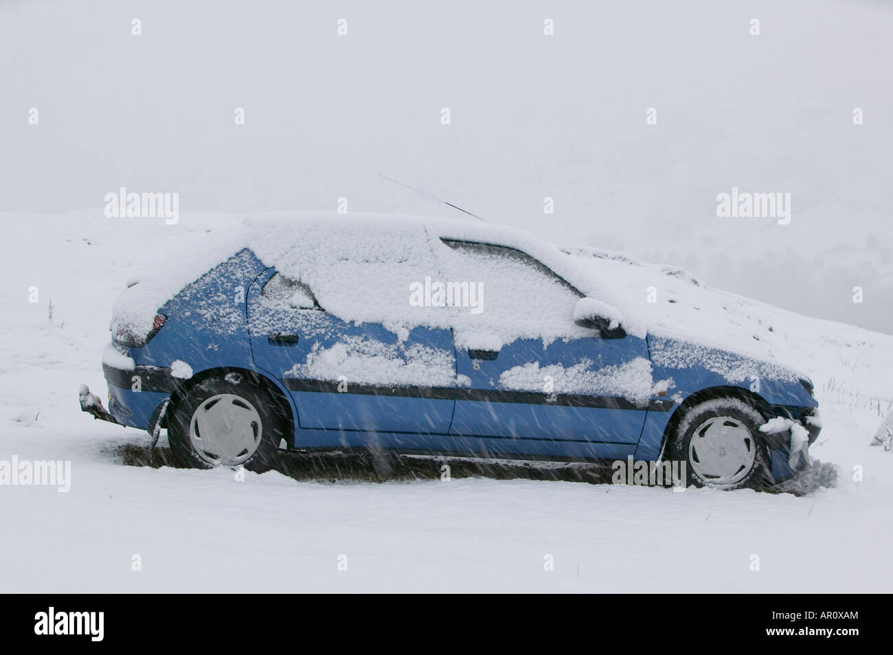 Une voiture abandonnée sur la puce dans le Lake District dans la neige lourde UK Banque D'Images