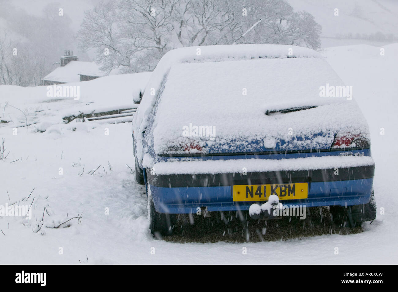 Une voiture abandonnée sur la puce dans le Lake District dans la neige lourde UK Banque D'Images
