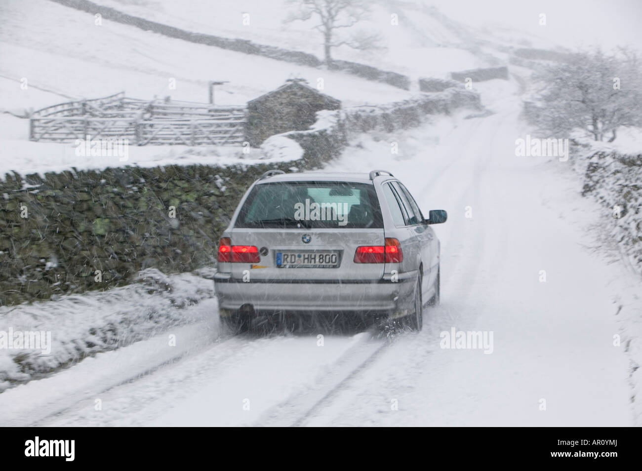 Une BMW conduite sur une puce dans le Lake District dans la neige lourde UK Banque D'Images
