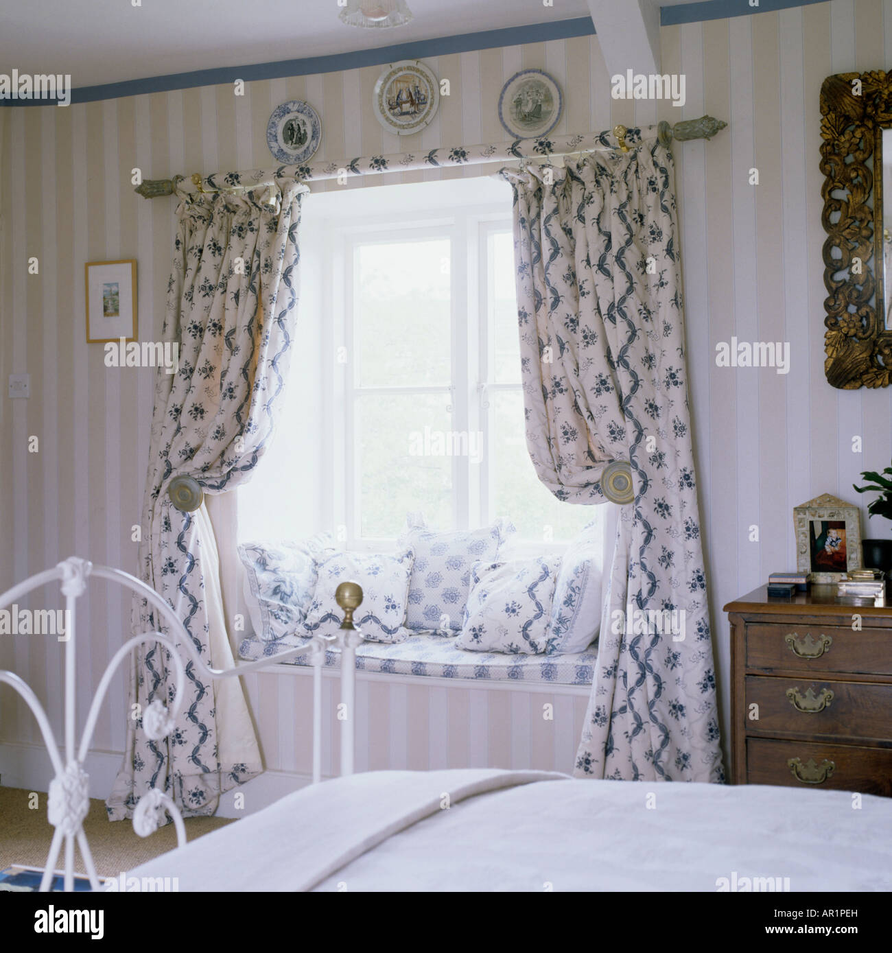 Lit en laiton et rideaux swagged dans une chambre à coucher dans une maison de campagne anglaise Banque D'Images