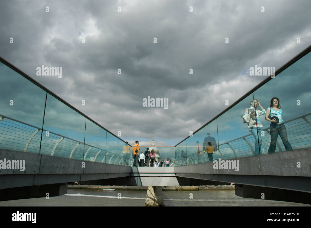 Les gens de marcher à travers le pont du millénaire avec la Cathédrale St Paul à la distance, London, England, UK Banque D'Images