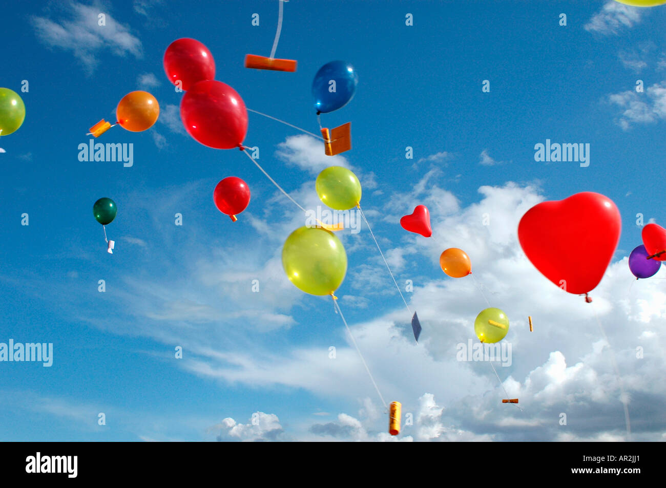 Ballons à l'hélium de couleur avec des messages flottant dans le ciel  au-dessus Photo Stock - Alamy