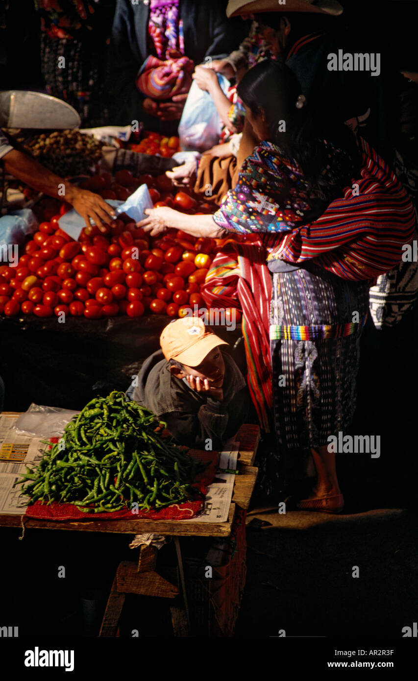 Boy daydreaming at vegetable stall, marché de Chichicastenango, Highlands, au Guatemala, en Amérique centrale. Banque D'Images