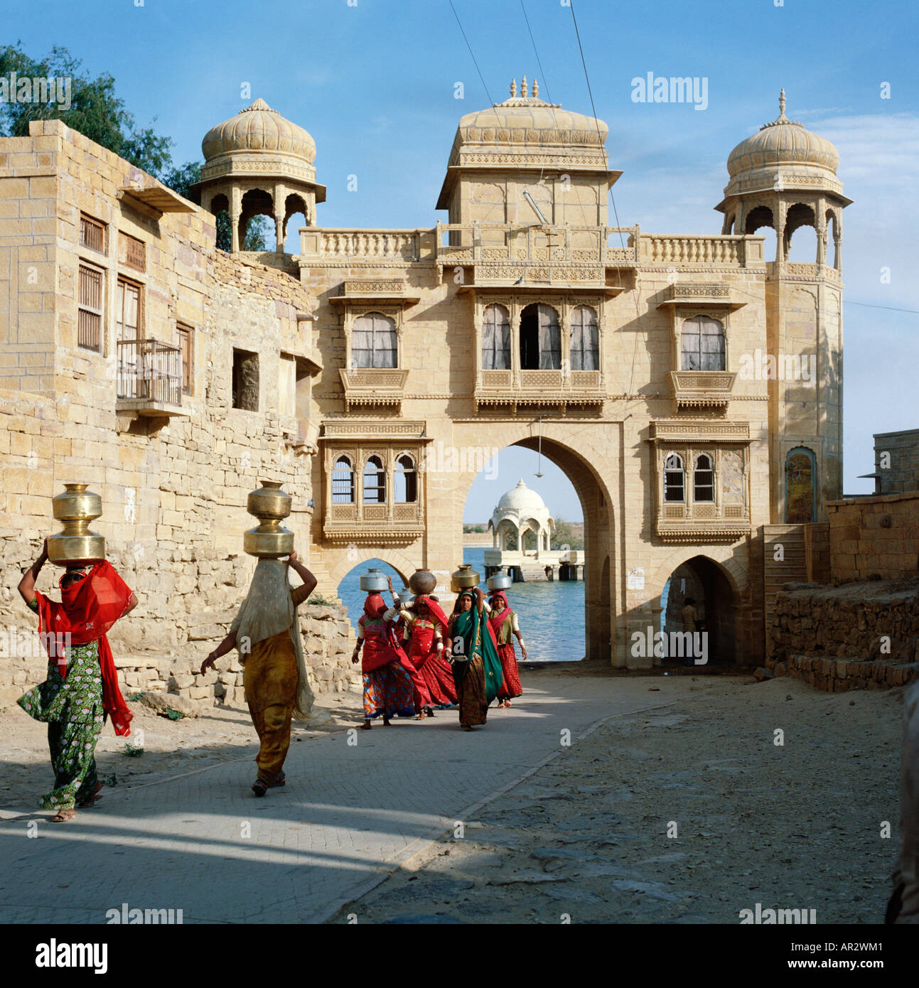 Les femmes indiennes du Rajasthan, Rajasthan avec des pots d'eau en laiton sur la tête de l'eau de Gadisar lake à Gadisar Gate, Jaisalmer, Inde Banque D'Images