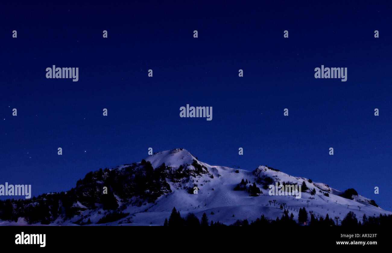 La montagne enneigée et pistes à Le Chinaillon en France dans la nuit. Banque D'Images
