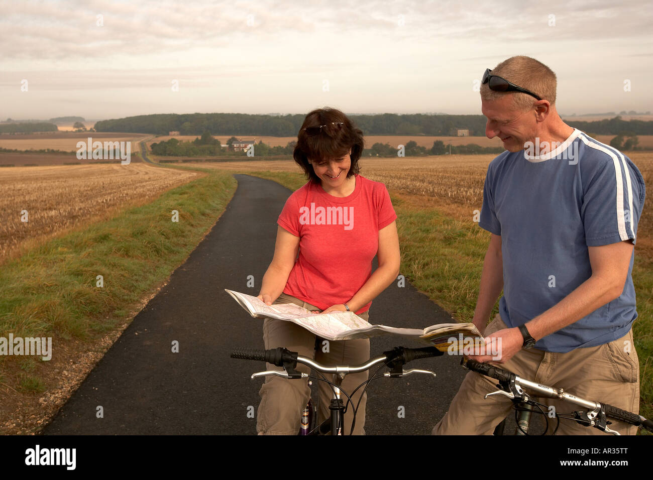 Couple à vélo et à la recherche à la carte dans la campagne les plateaux près de South Dalton East Yorkshire UK Banque D'Images