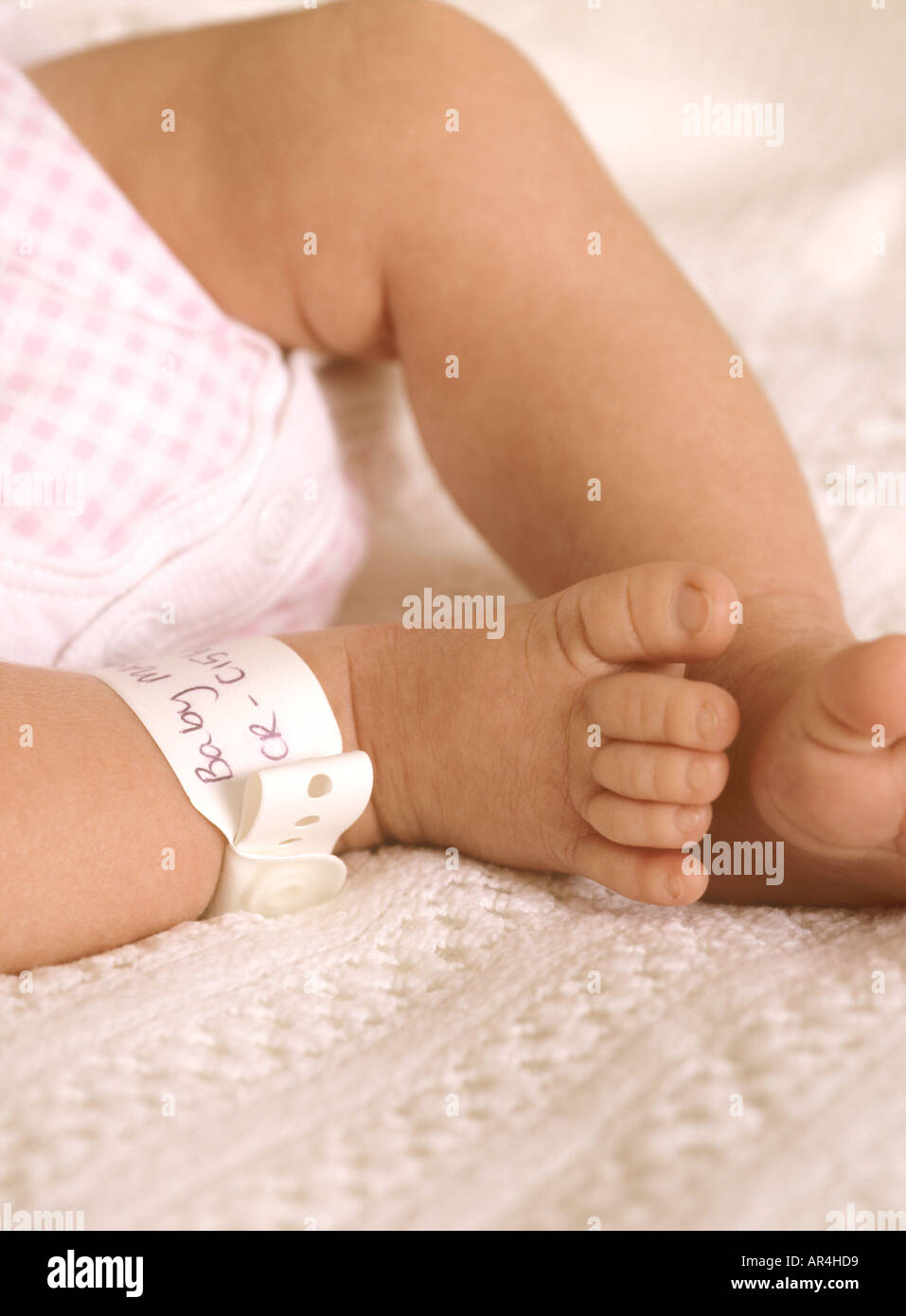 Gros plan sur les pieds et le bracelet d'identité de la jeune fille, petits orteils mignons, Royaume-Uni, Royaume-Uni Banque D'Images