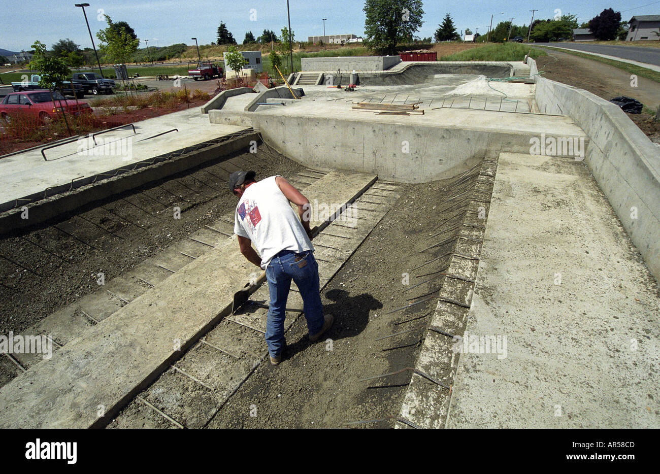 Travailleur de la construction fonctionne sur ciment skate park half pipe Banque D'Images