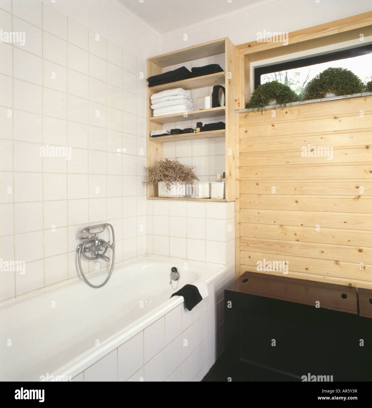 Au-dessus des étagères en 70 Salle de bains avec baignoire mur carrelé  blanc et sur les plantes d'étagère au-dessus des lambris en pin Photo Stock  - Alamy