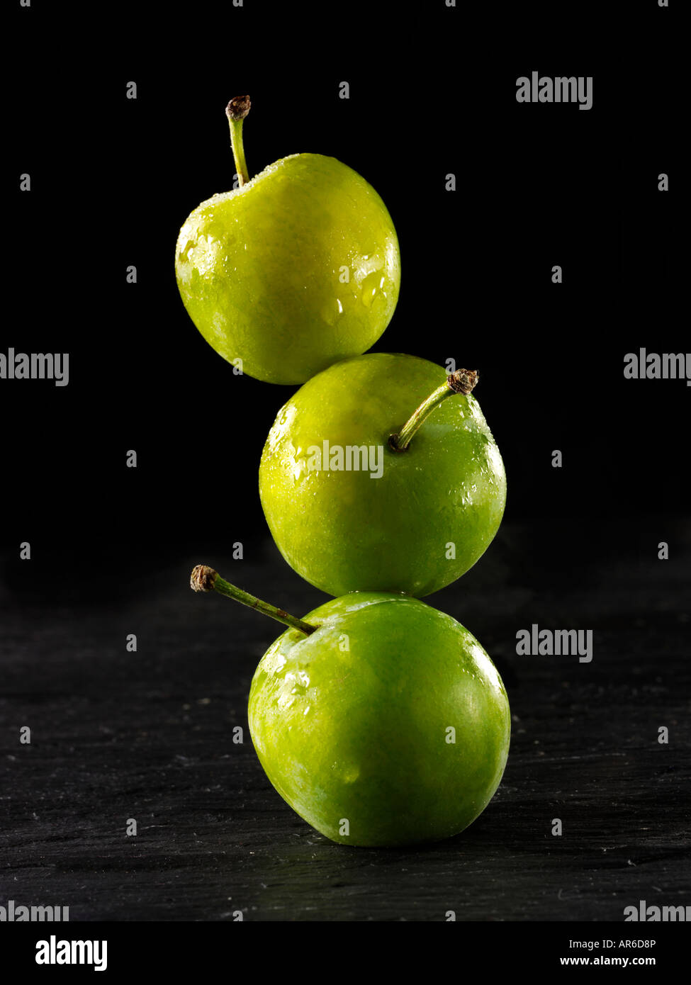 Tas de matière organique fraîche Greengage prunes vertes sur fond noir Banque D'Images