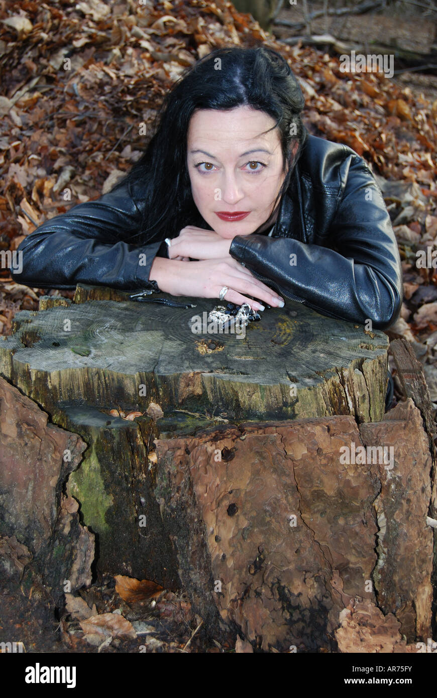 Femme en noir modèle posant dans woods, Virginia Water, Surrey, Angleterre, Royaume-Uni Banque D'Images
