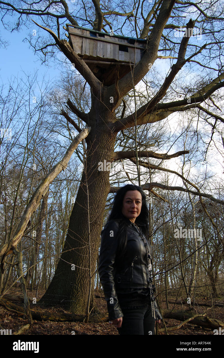 Femme en noir modèle posant dans woods, Virginia Water, Surrey, Angleterre, Royaume-Uni Banque D'Images