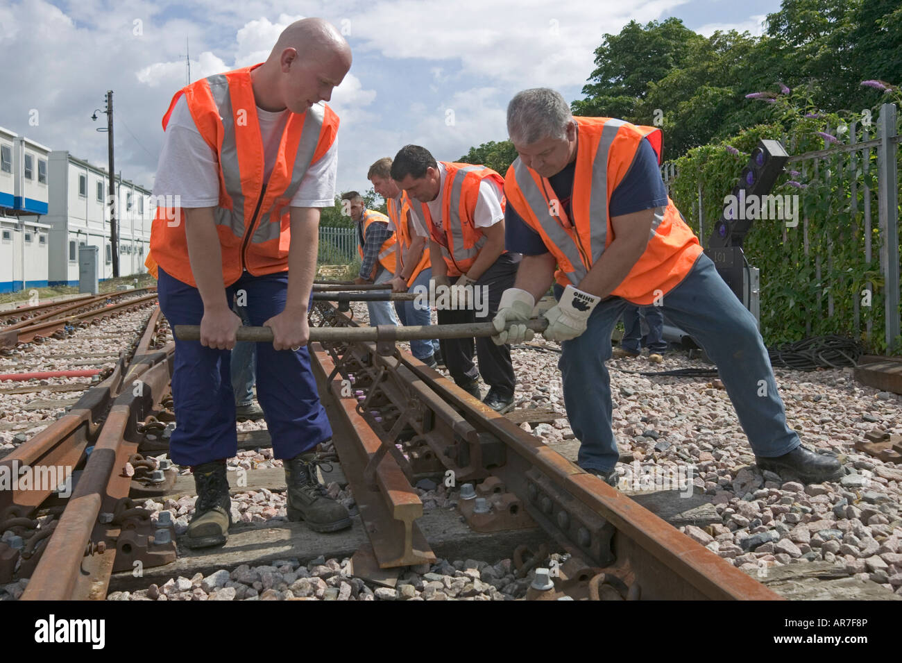 Les travailleurs ferroviaires lourds pratique les techniques de levage en cours d'instruction pour essayer de prévenir de graves blessures au dos sur des sites ferroviaires. Banque D'Images