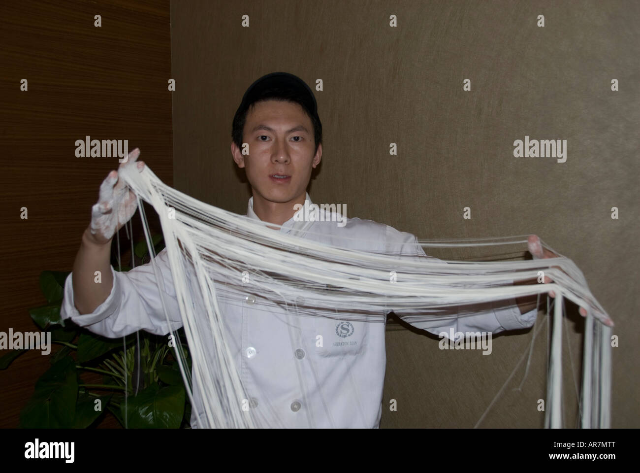 Chef de donner une leçon de nouilles balançant la pâte en fines lanières Xian dans la province du Shaanxi en Chine. Banque D'Images