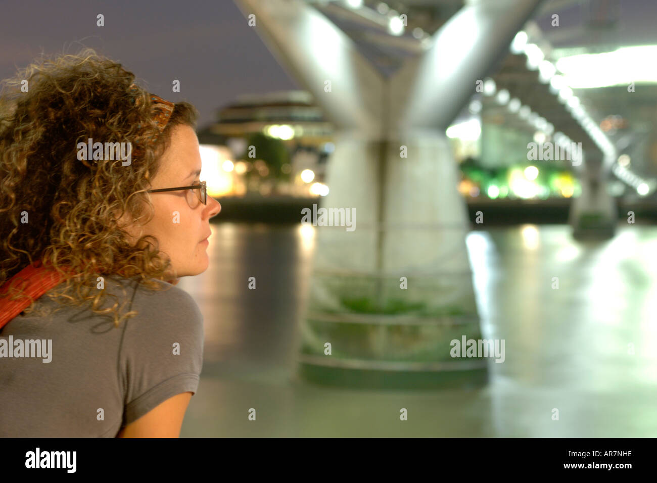 Portrait d'une jeune fille sous le Millenium Bridge à Londres la nuit. Banque D'Images