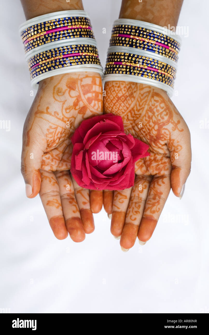 Indian girl with henna hands holding red rose Banque D'Images