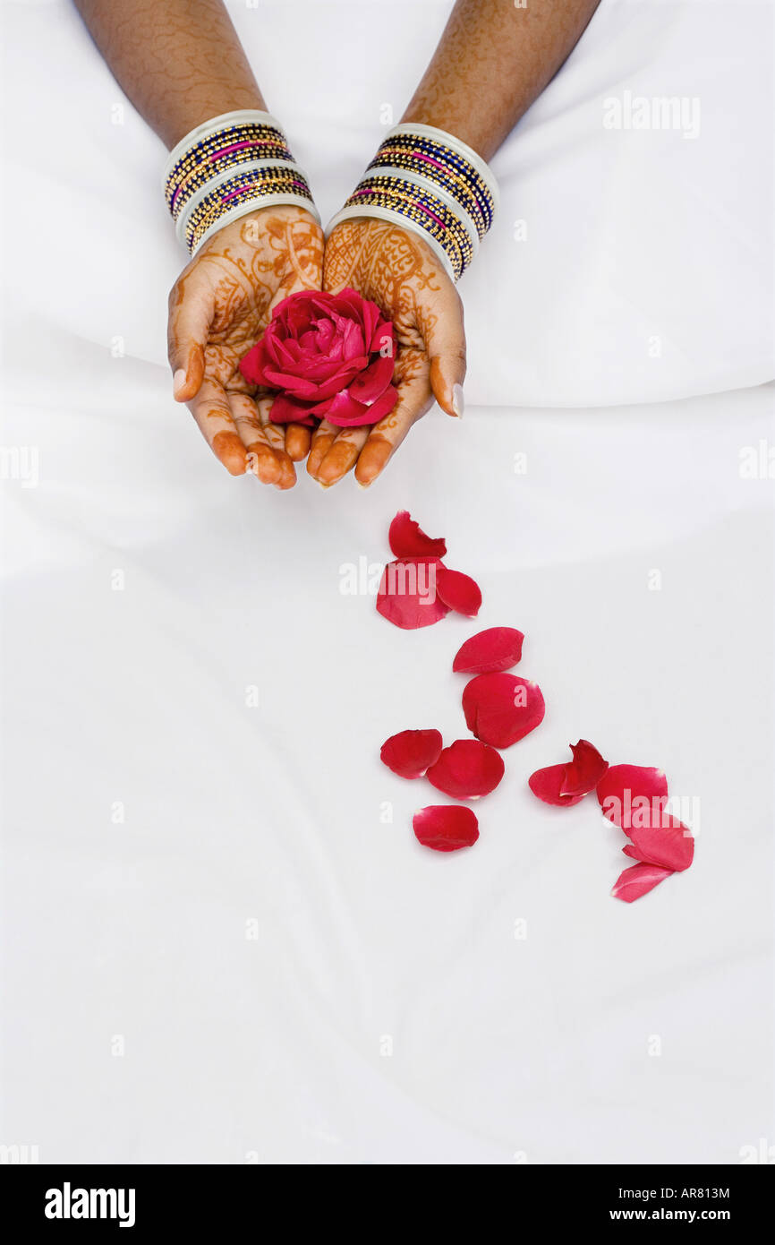 Indian girl with henna hands holding red rose et les pétales Banque D'Images