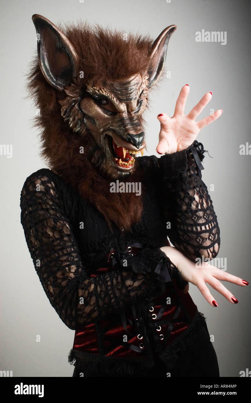 Une femme portant un masque de loup-garou en latex et des vêtements de style victorien. Banque D'Images