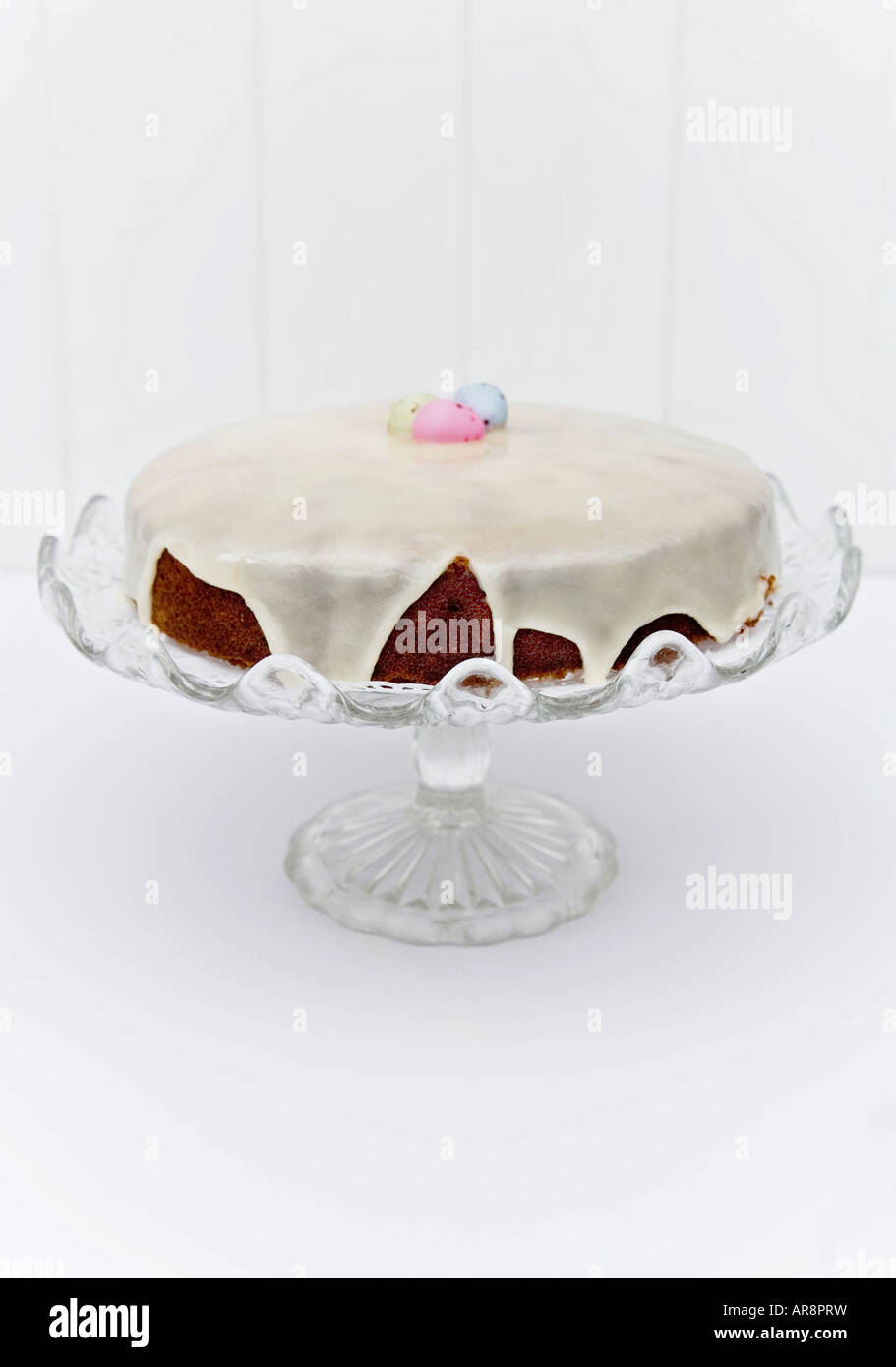 Gâteau de Pâques faits maison avec du glaçage et fondant au chocolat enrobés de sucre avec des oeufs de pâques servi sur un cake stand vintage. Banque D'Images