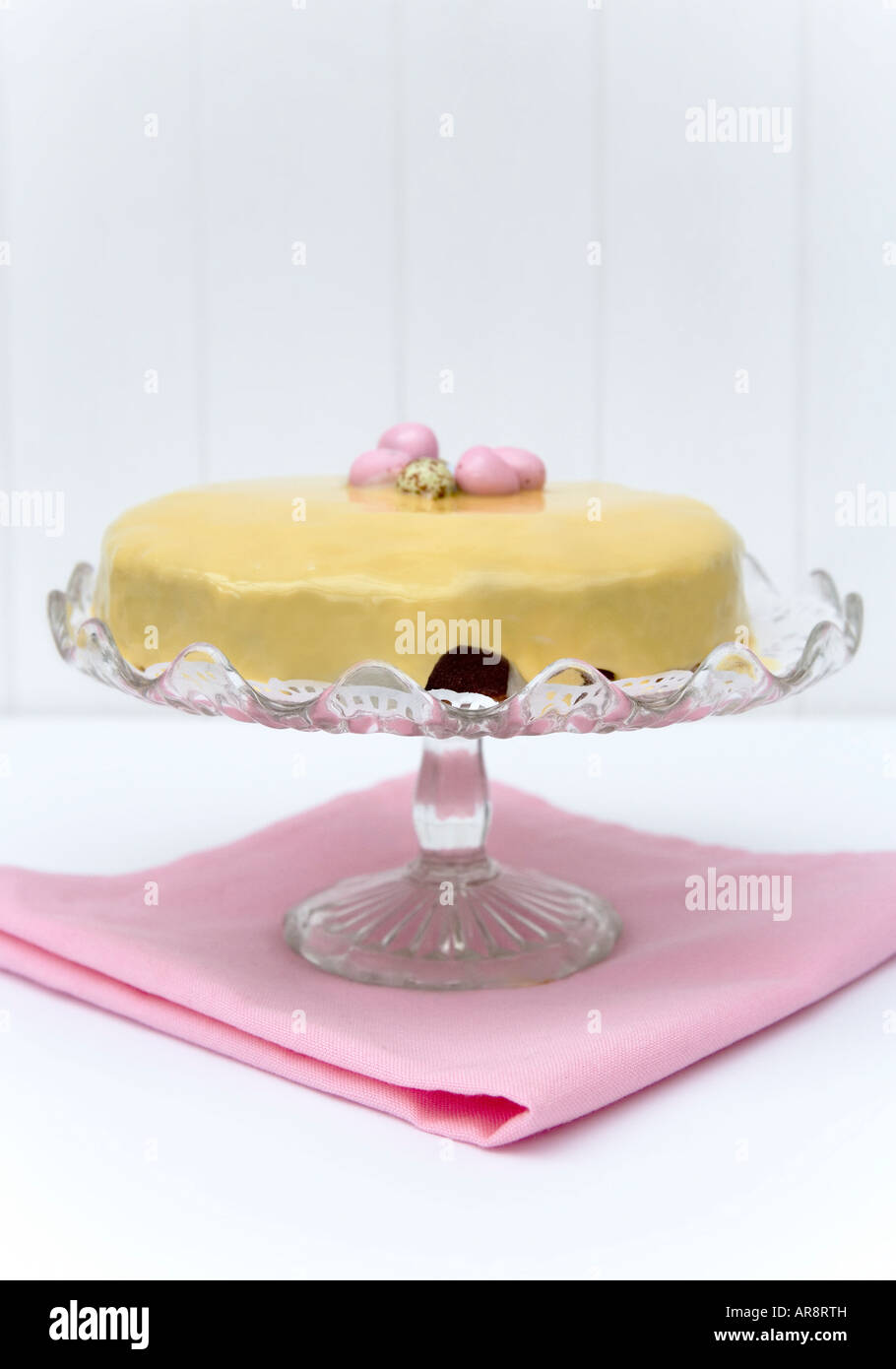 Gâteau de Pâques faits maison avec du glaçage et fondant au chocolat enrobés de sucre avec des oeufs de pâques servi sur un cake stand vintage. Banque D'Images