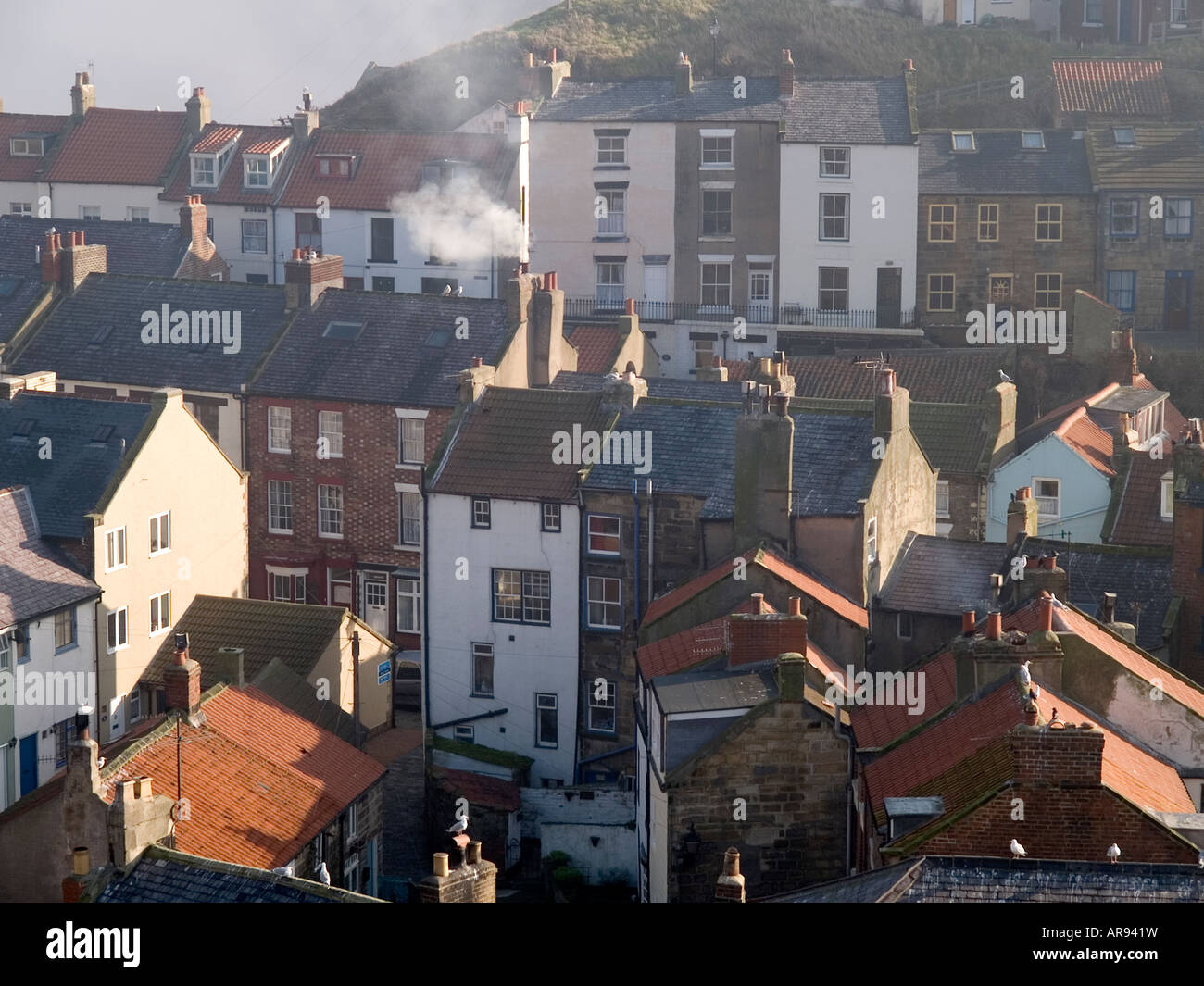 Close up de chalets dans le village de pêcheurs historique de Staithes Yorkshire du Nord montrant la fumée de combustion du charbon encore autorisée Banque D'Images