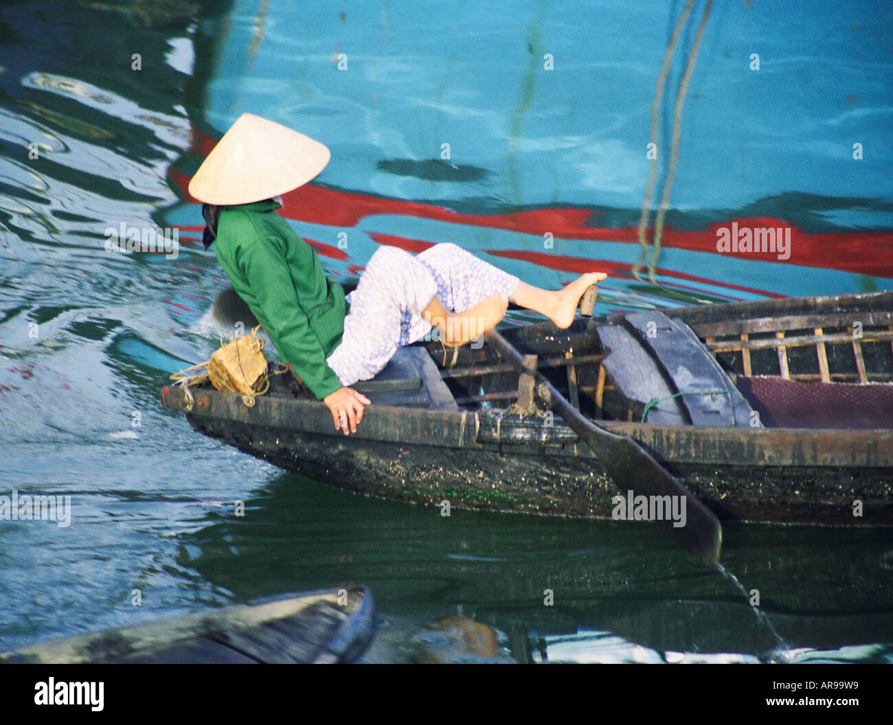 Vietnam, Woman Rowing Boat avec ses pieds Banque D'Images