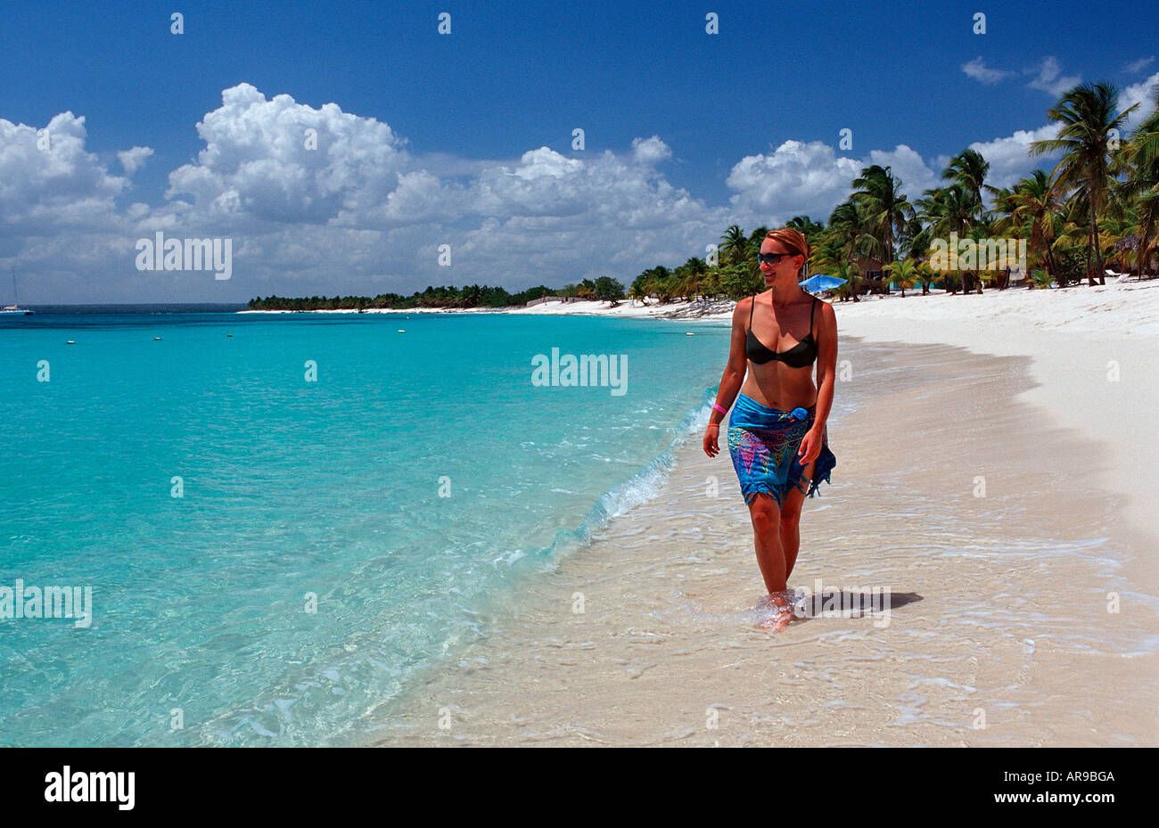 Femme marche sur la plage de sable de l'île Catalina Caraïbes République dominicaine Banque D'Images