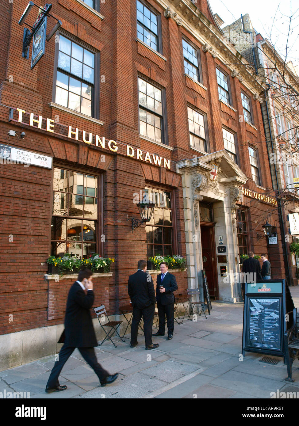 Les travailleurs de la ville ayant un verre à l'heure du déjeuner à l'extérieur de l'Hung écartelés pub Ville de London Tower Hill Banque D'Images