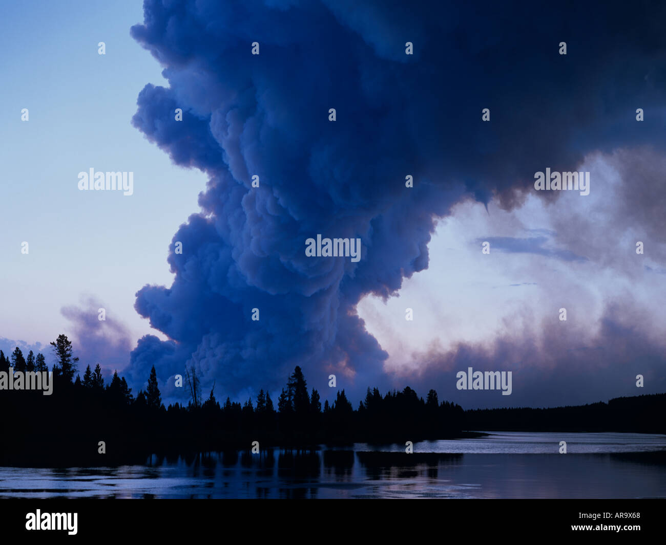 De Forêt à forêt avec grand panache de fumée reflétée dans la rivière Yellowstone, le Parc National de Yellowstone, Wyoming, USA Banque D'Images
