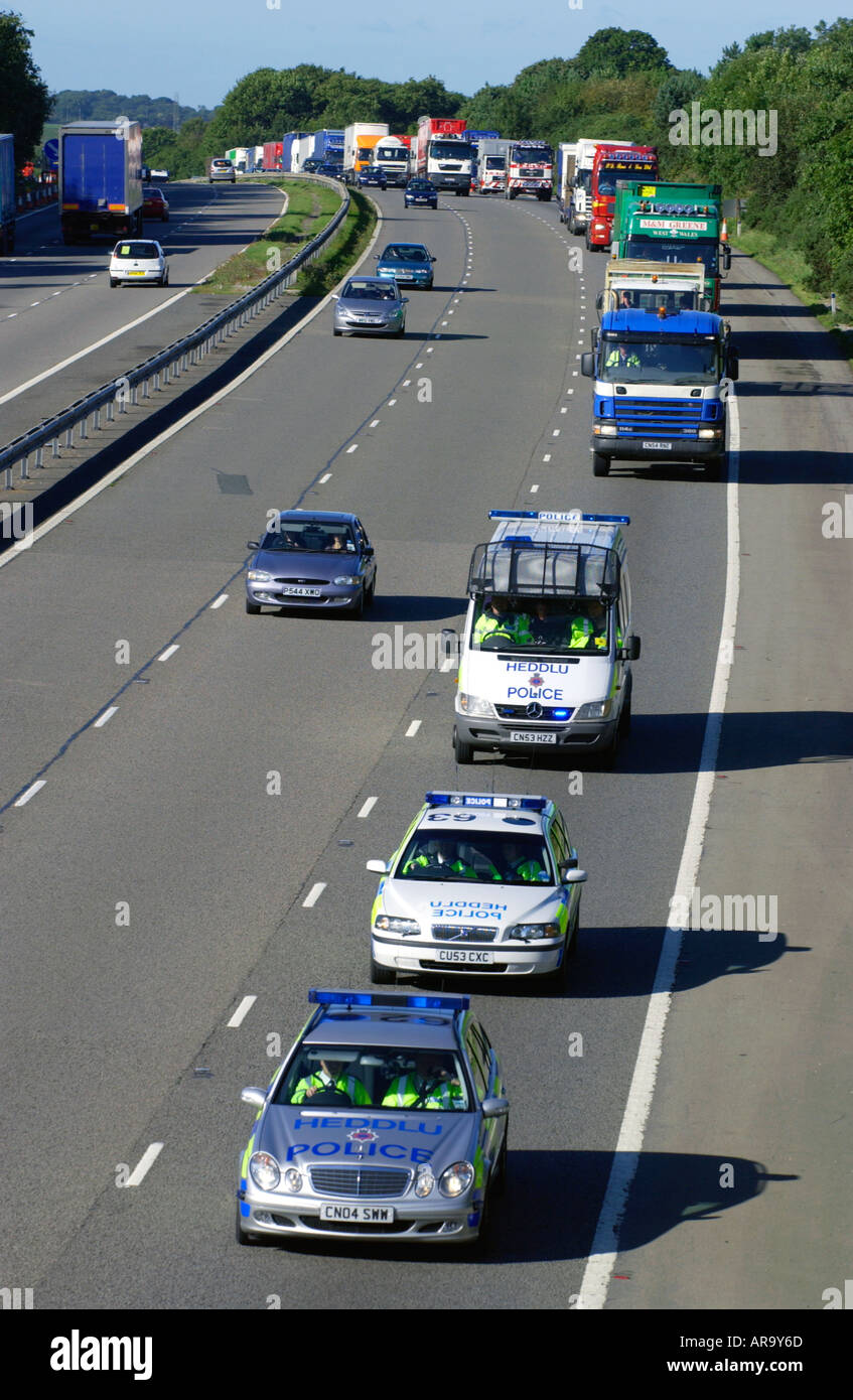 Les véhicules de la police à la tête d'une protestation lent convoi de camions sur M4 dans le sud du Pays de Galles contre les gouvernements britanniques des impôts sur le carburant Banque D'Images