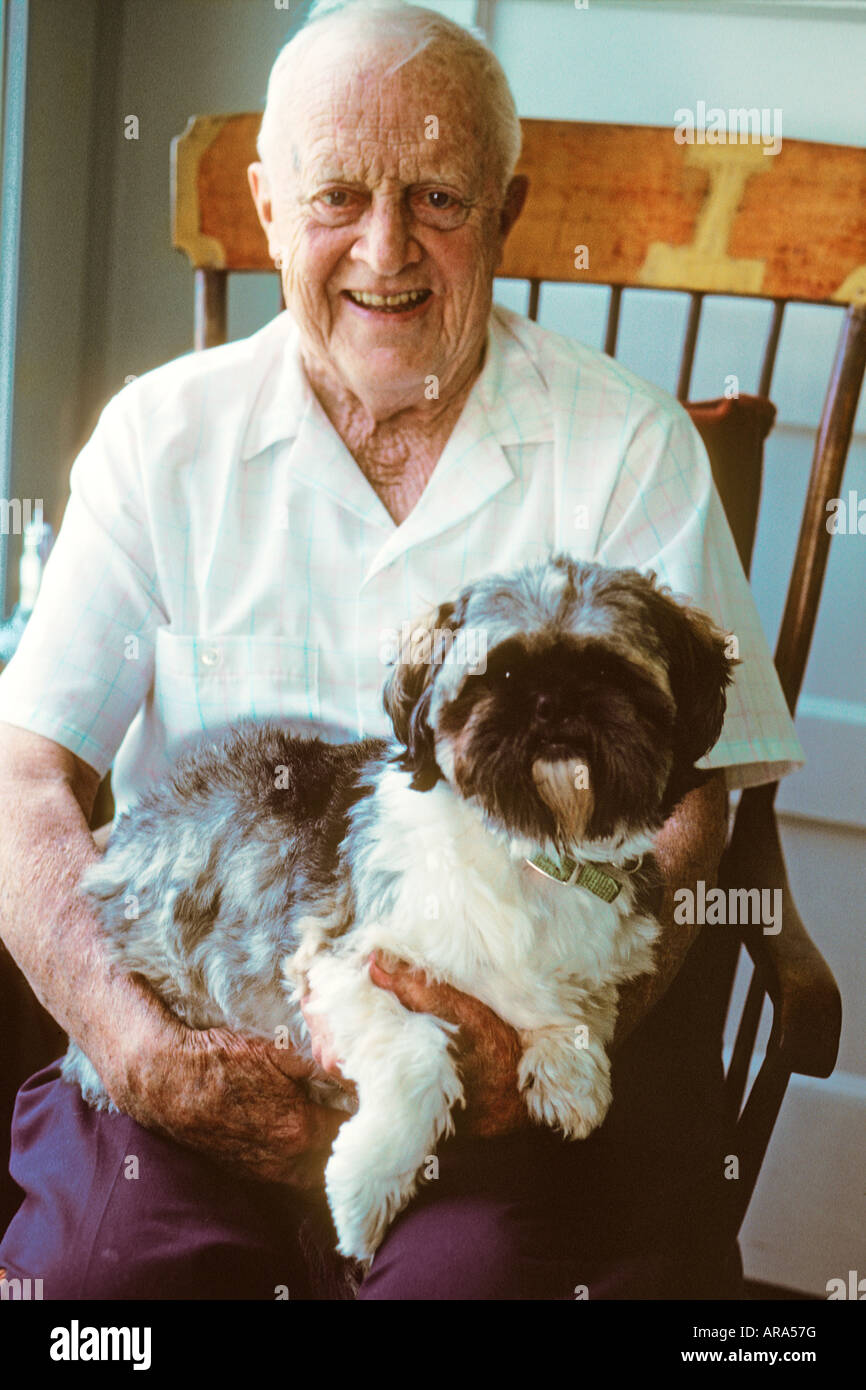 Senior citizen sur rocking chair avec chien meilleur ami Banque D'Images