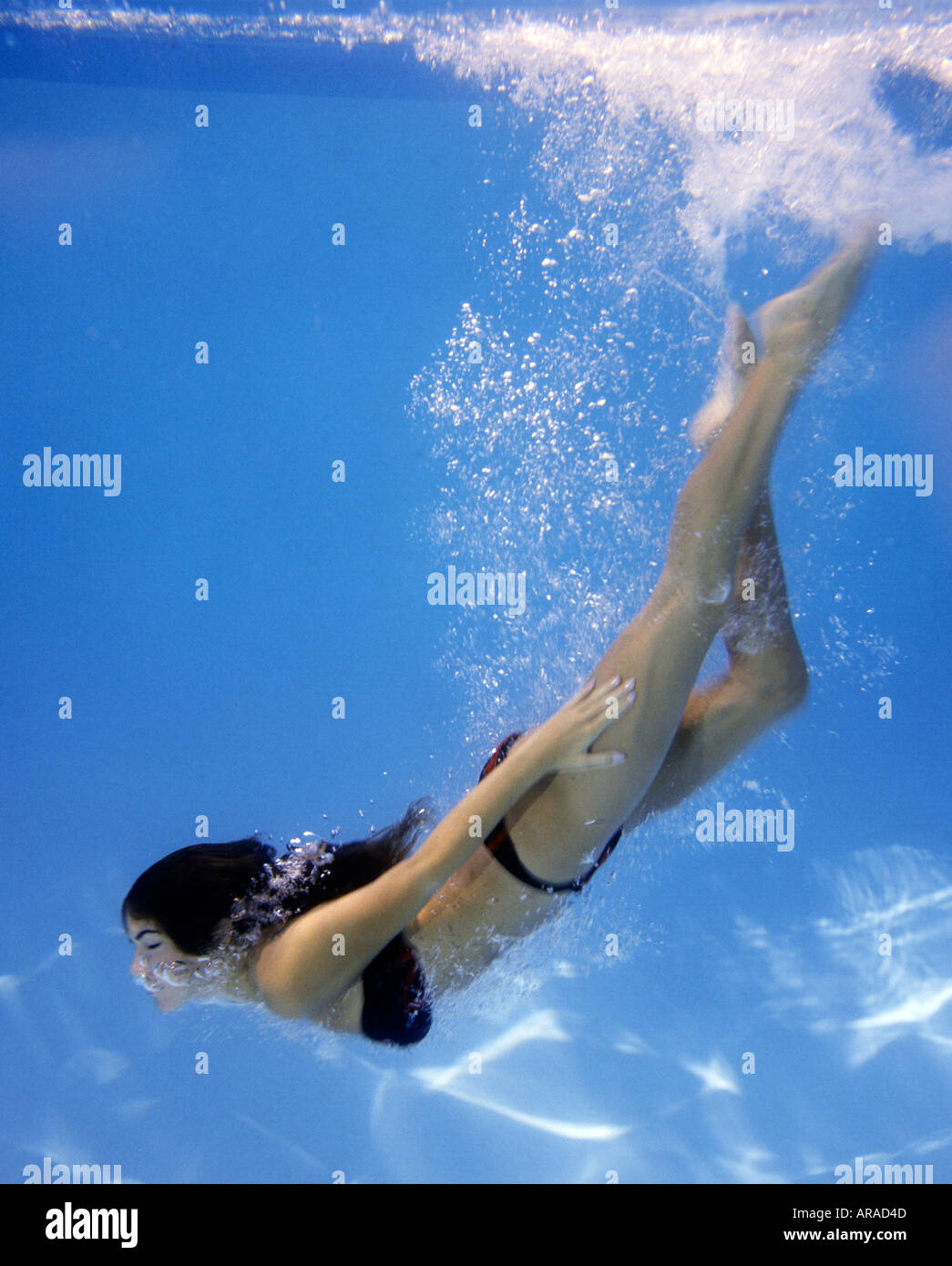Girl swimming underwater in pool Banque D'Images