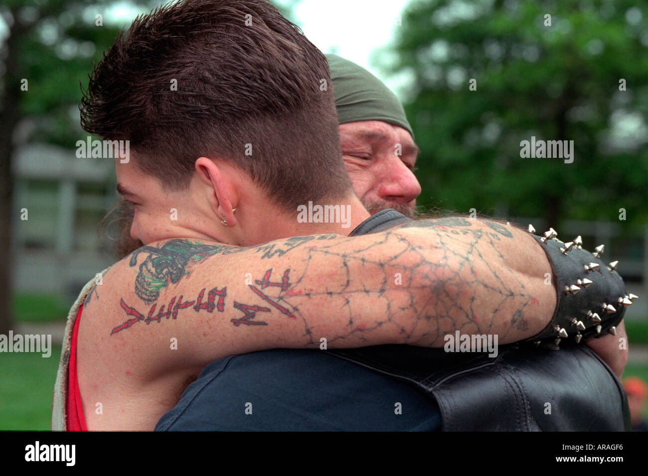 L'âge de 55 ans, vétéran du Vietnam biker embrassant l'homme (fils ?) l'âge de 24 ans à la cérémonie du Jour du Souvenir. St Paul Minnesota MN USA Banque D'Images