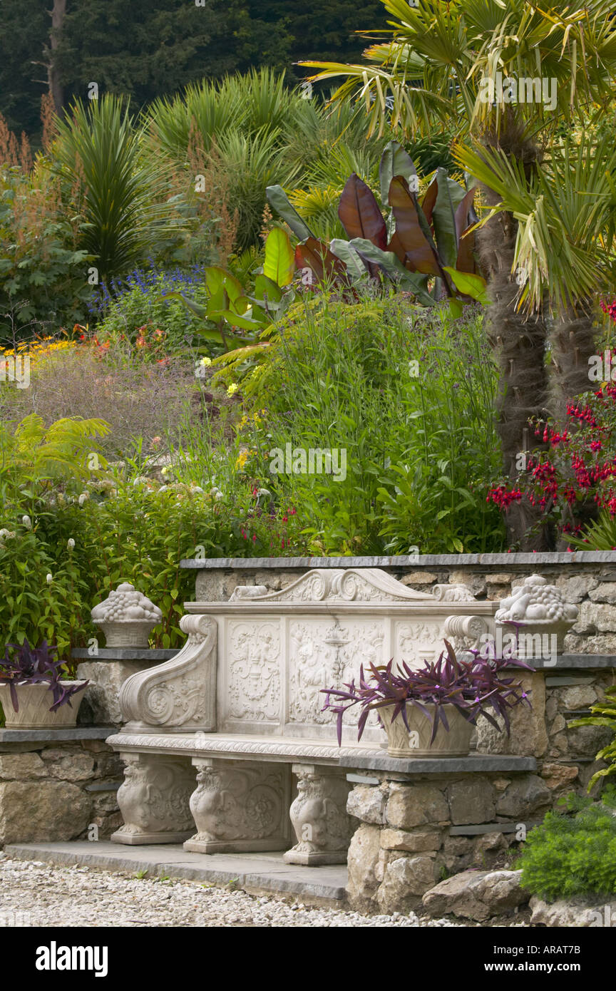 Yewbarrow chambre jardin avec banc calcaire plantation exotique avec des piliers de croissance aux côtés de l'hosta Fuschia Banque D'Images