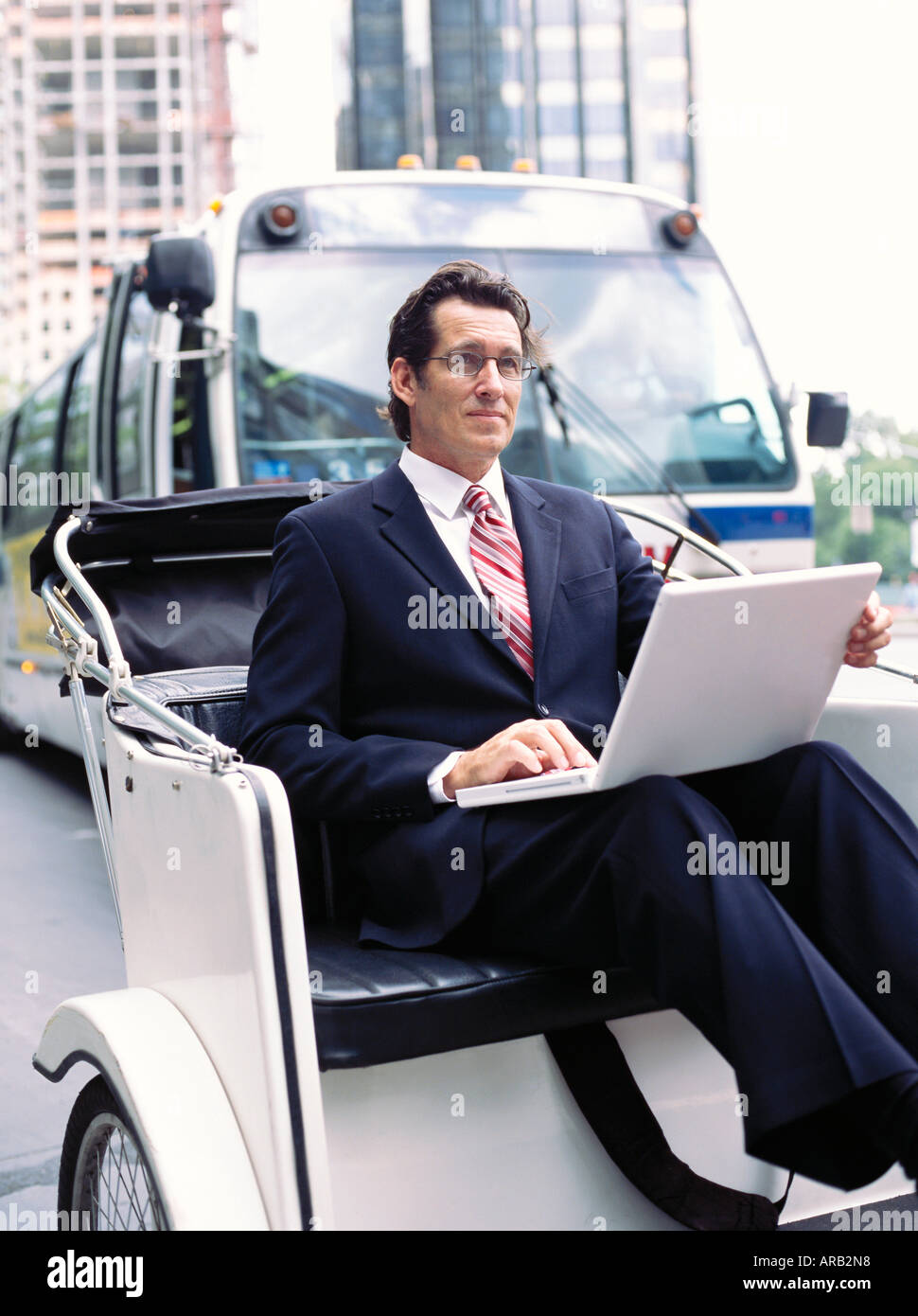 Businessman With laptop computer, assis en Rickshaw Banque D'Images