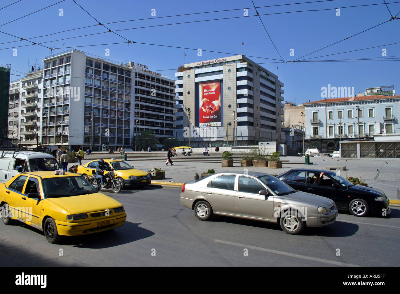 Cars et taxis en passant par la place Omonia Athènes centre-ville lumière du jour de l'aire centrale Grèce capitale transport transaportation motion Banque D'Images