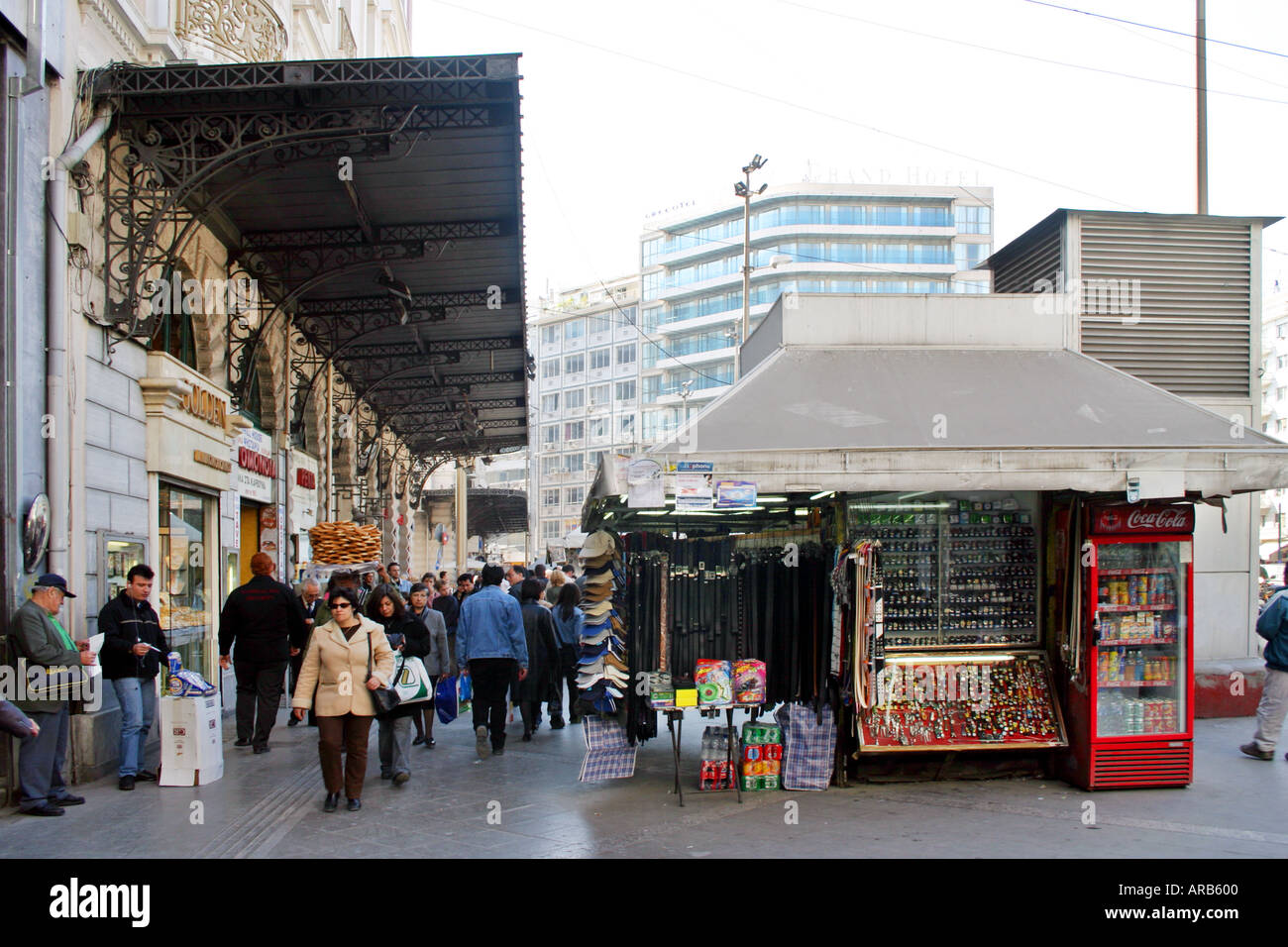 Les piétons circulant sur la chaussée centrale kiosque place Omonia Athènes Grèce capitale ville zone marchandises hiver vente stuff Banque D'Images