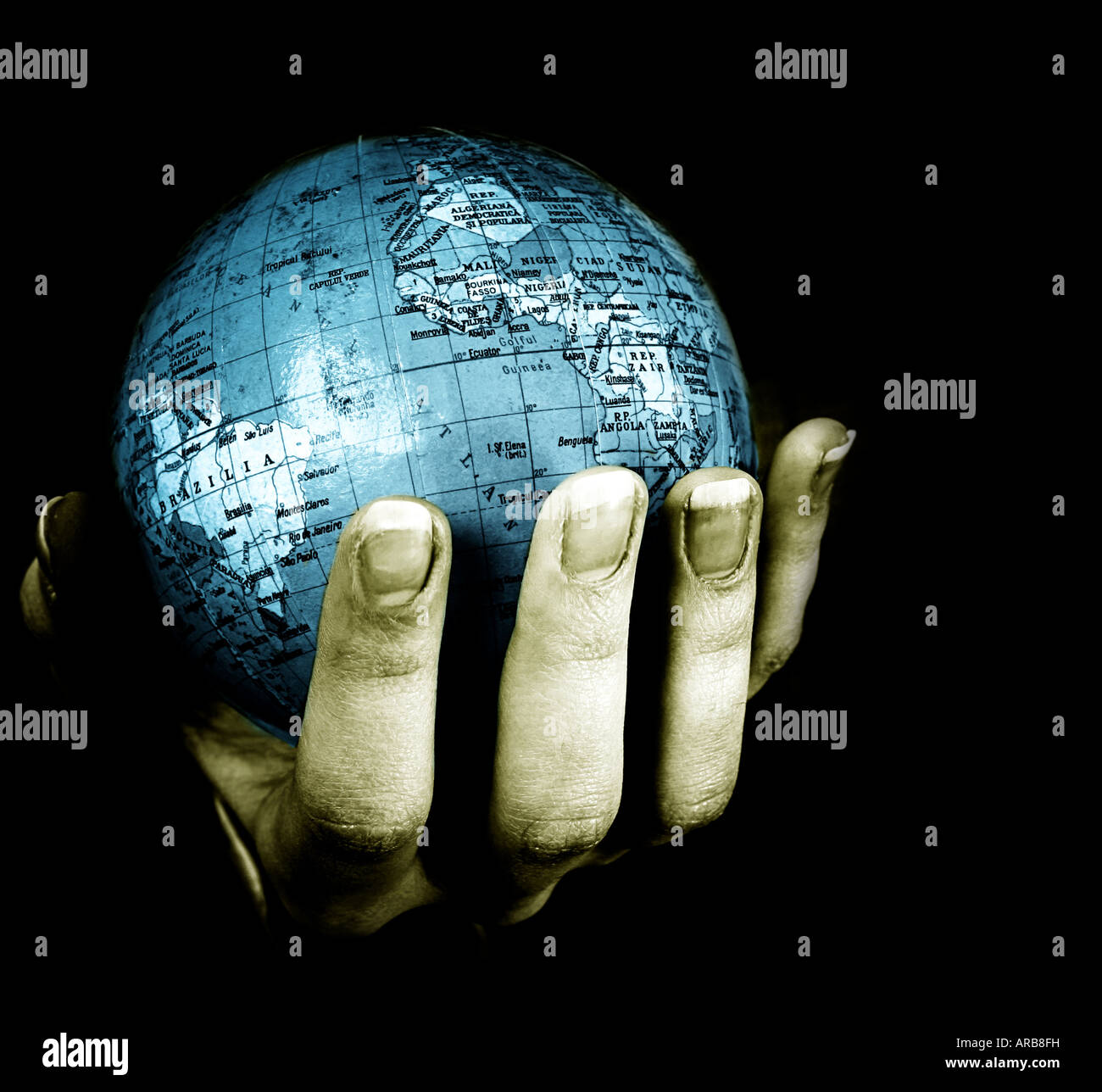 Globe in a girl's hands. Macro image isolated on black Banque D'Images