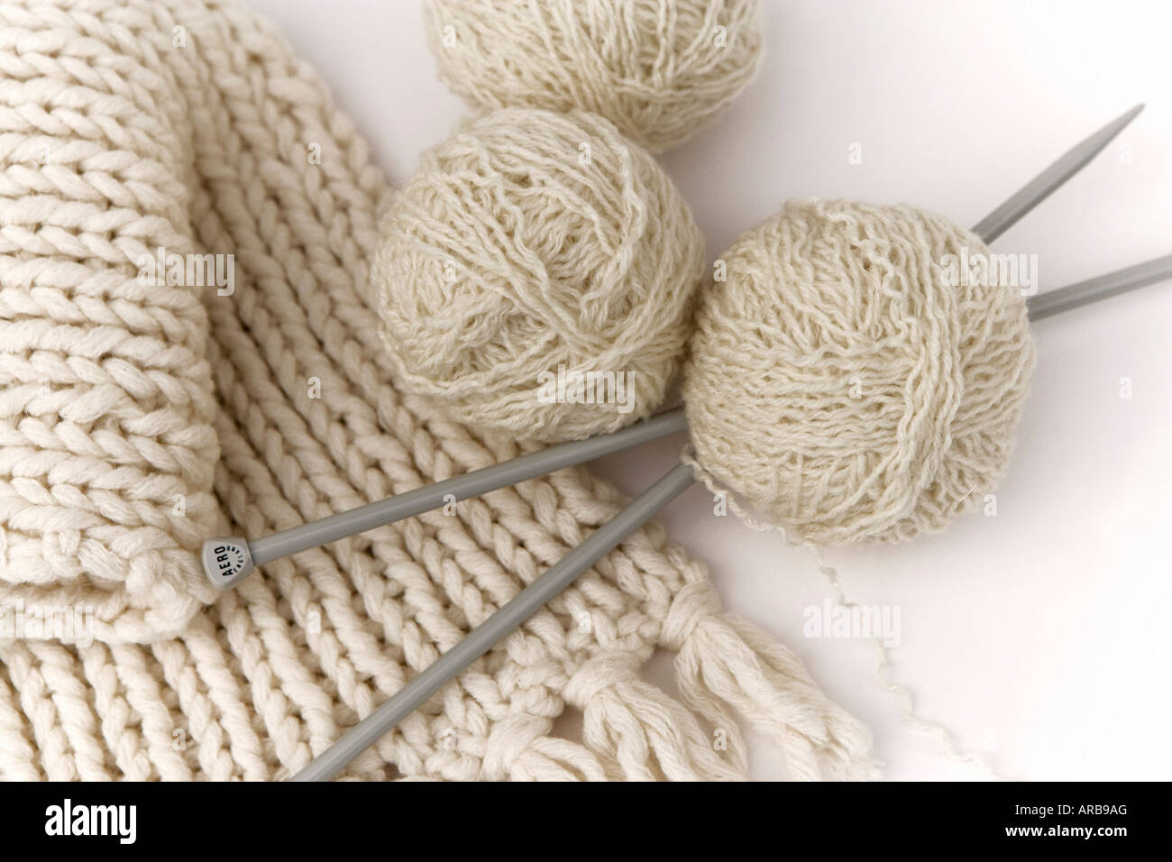 Des aiguilles à tricoter, de la laine et un foulard crème tricot Banque D'Images